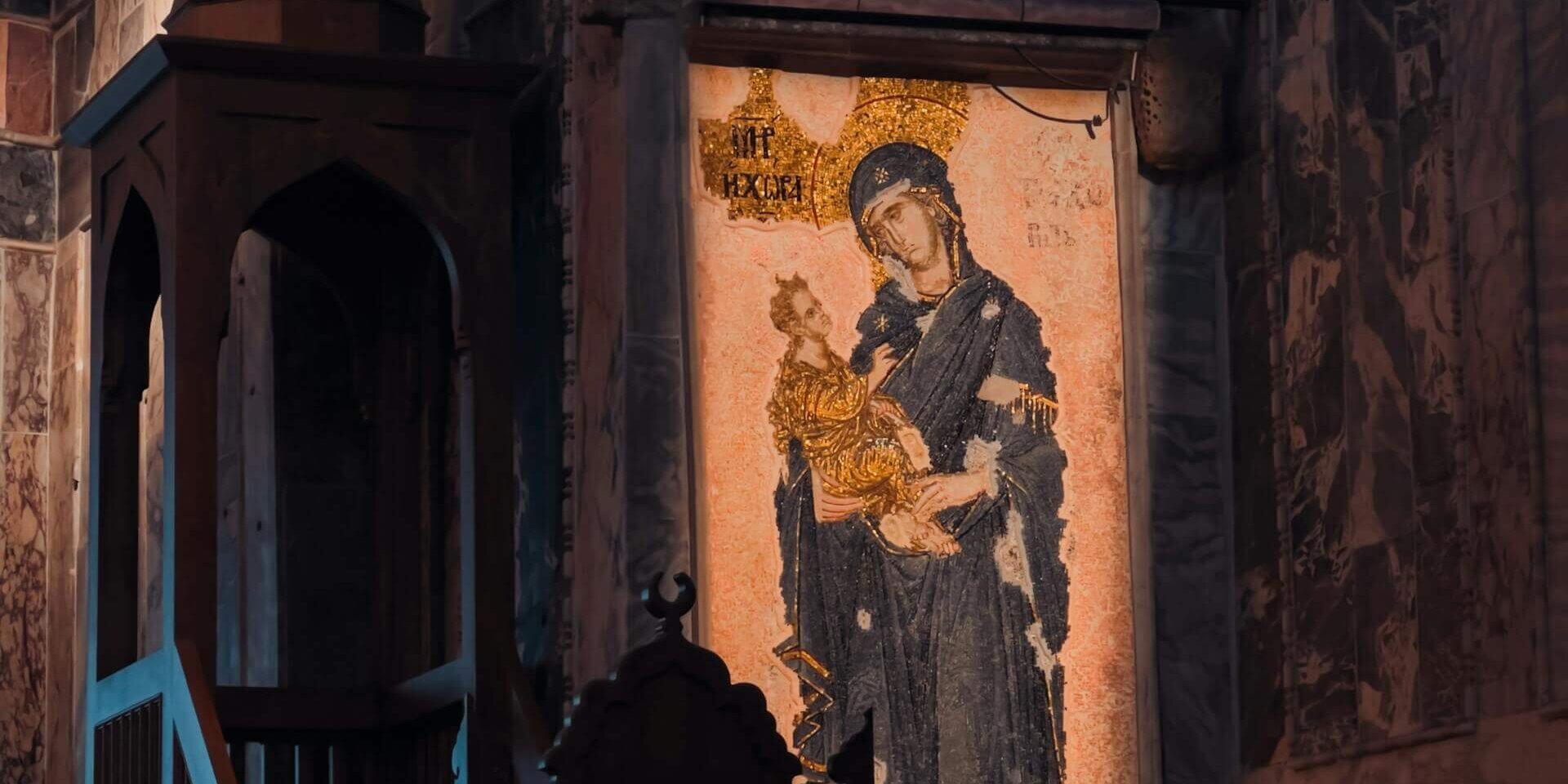 Mosaic of Virgin Mary and Child in an ancient church interior.